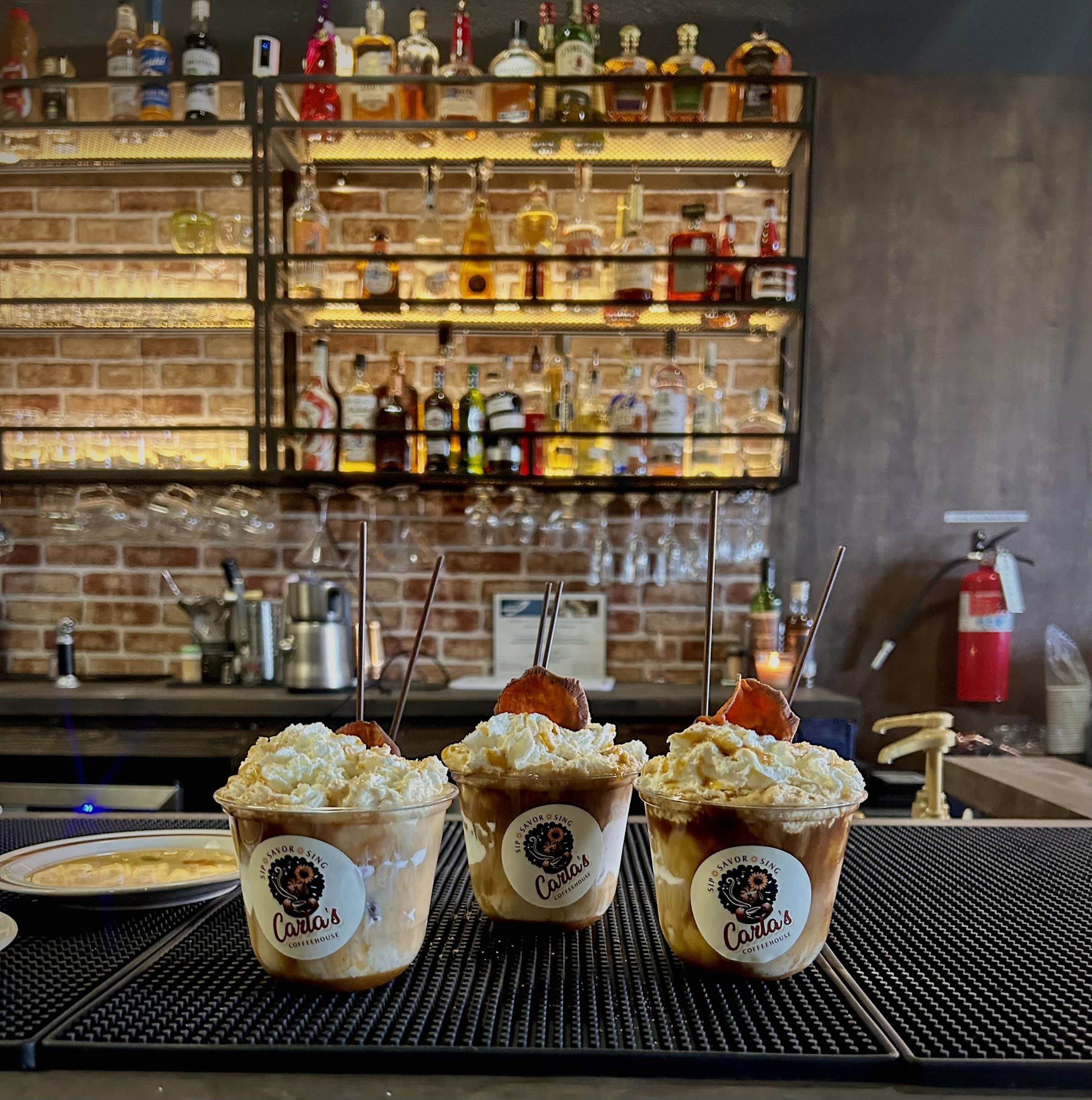 Carla's Coffeehouse specialty drinks topped with whipped cream at the bar