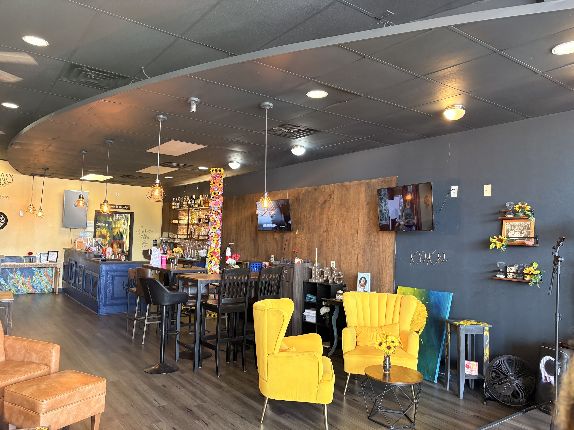 Wide view of Carla's Coffeehouse interior with yellow chairs and eclectic decor.