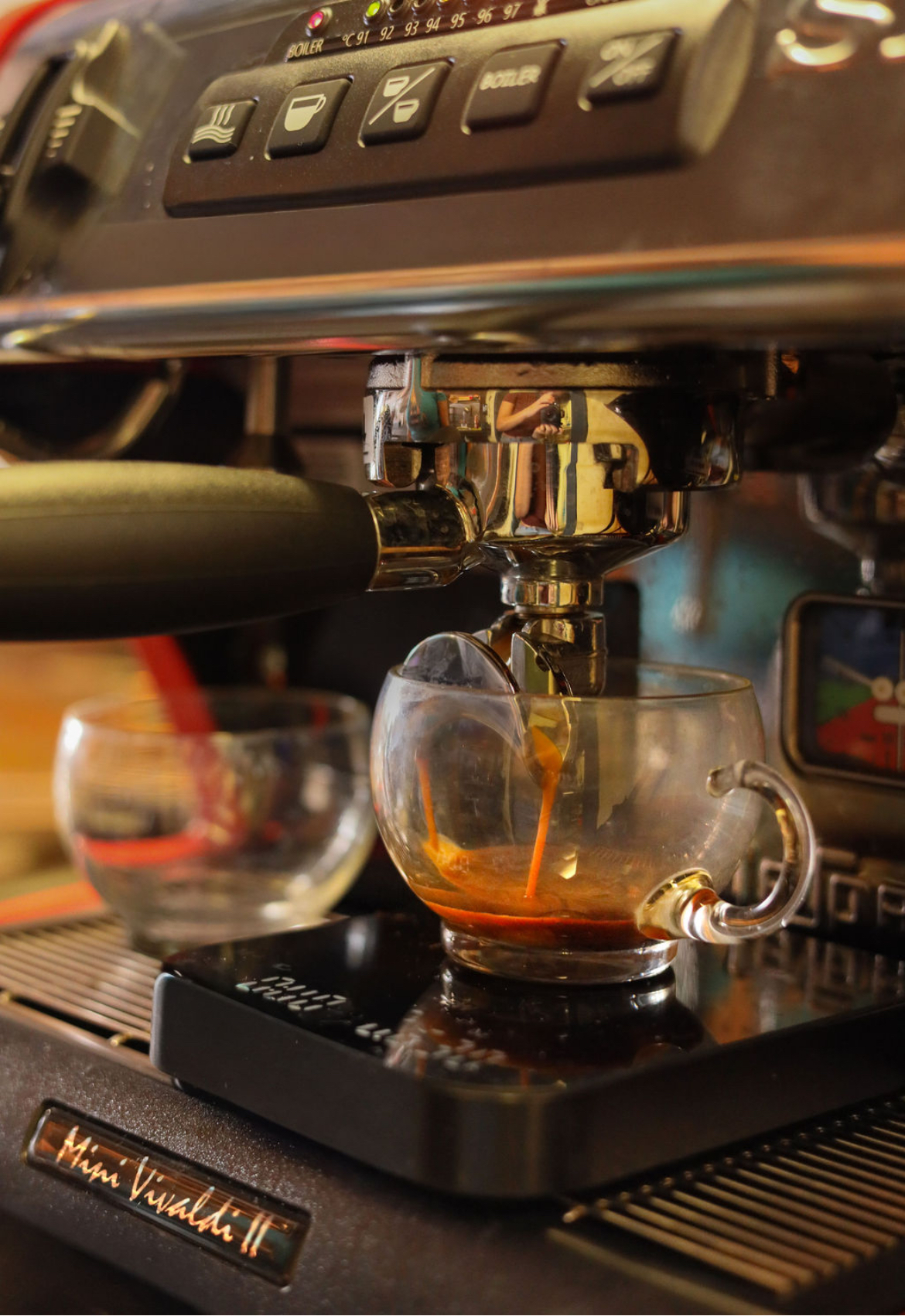Fresh espresso pouring into a glass cup