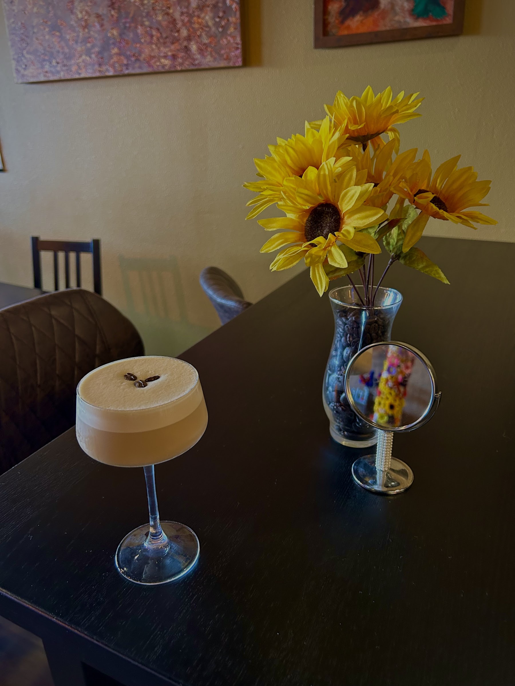 Espresso martini beside sunflowers and coffee beans